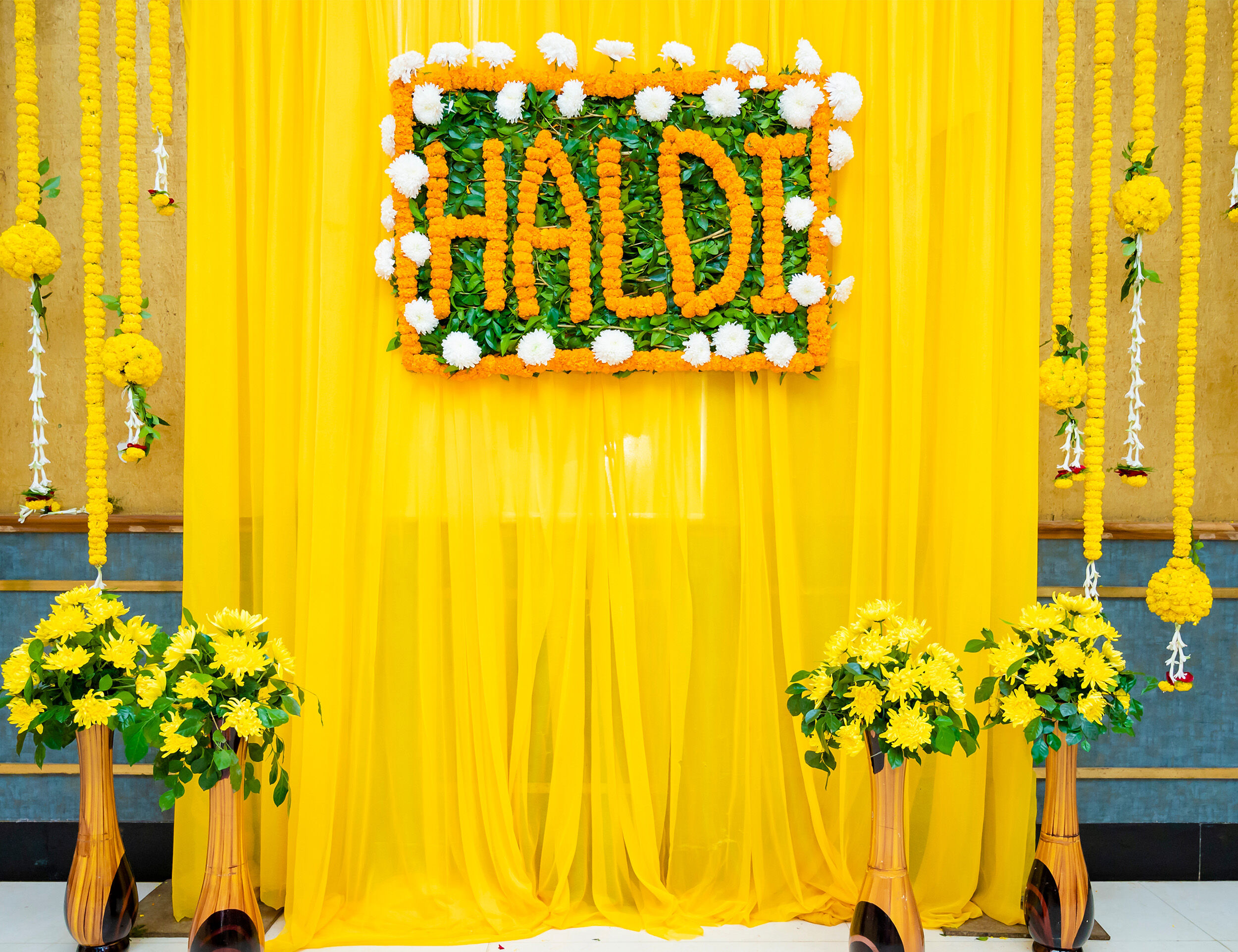 A handmade Haldi name with yellow flowers at home 